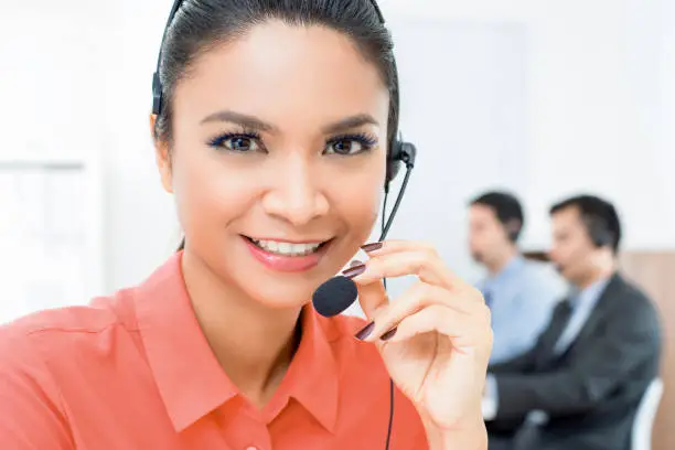 Smiling beautiful Asian woman telemarketing customer service agent working in call center office